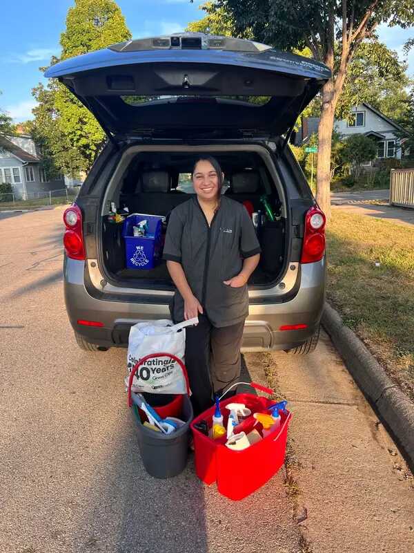 Diana in casual clothes holding cleaning supplies